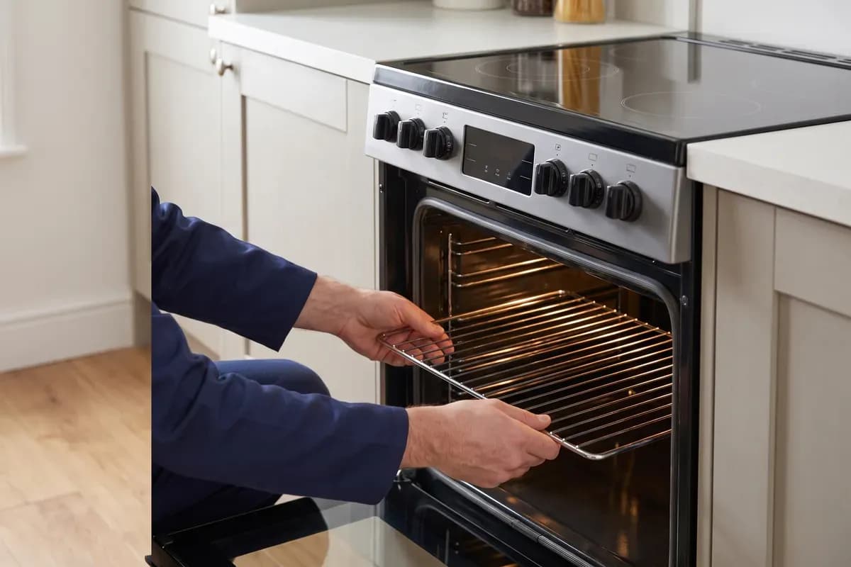 An engineer carrying out electric cookers repairs in a customer's home